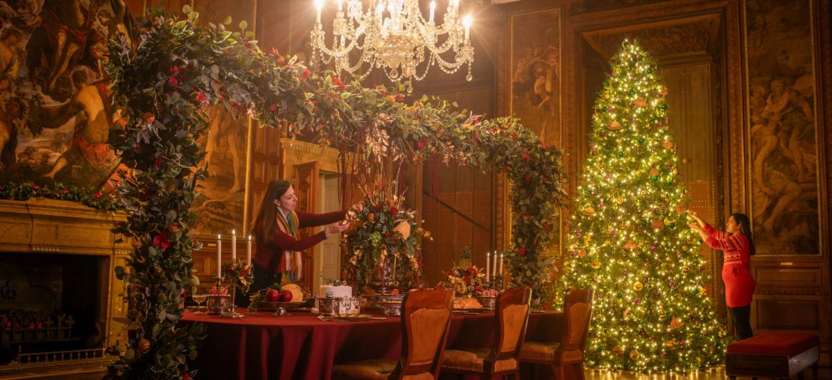 Two women putting up Christmas decorations inside Kingston Lacy in Dorset