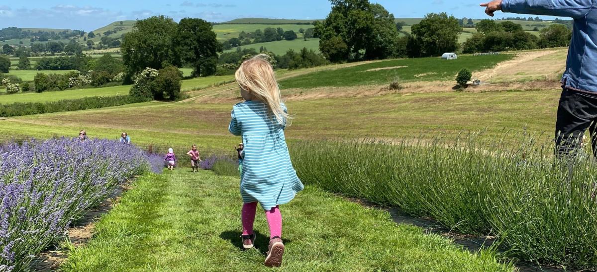 A girl walking through a field in the countryside near Sherborne, Dorset