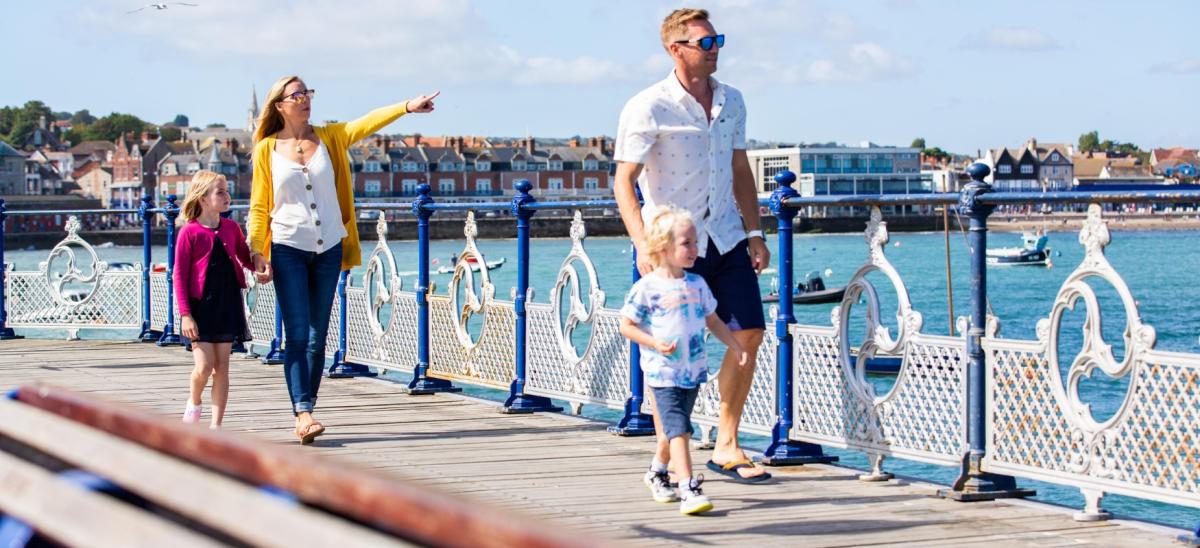 A family walking along Swanage Pier in Dorset