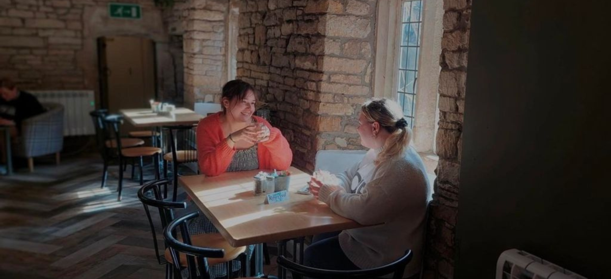 2 young ladies drinking a coffee at the Secret Garden Cafe in Dorchester