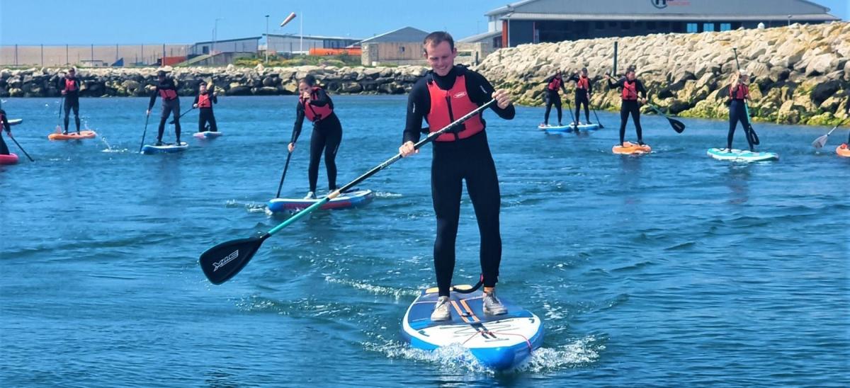 Group of people paddleboarding with Adventure 4 All at Portland Marina, Dorset