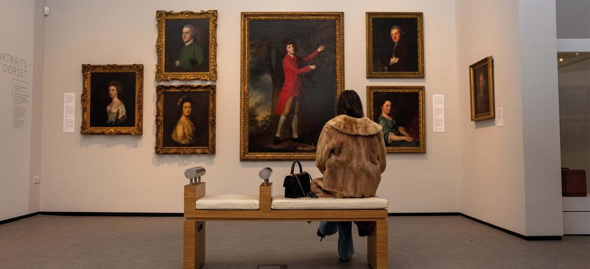 A woman looking at paintings in the Dorset Museum & Art Gallery
