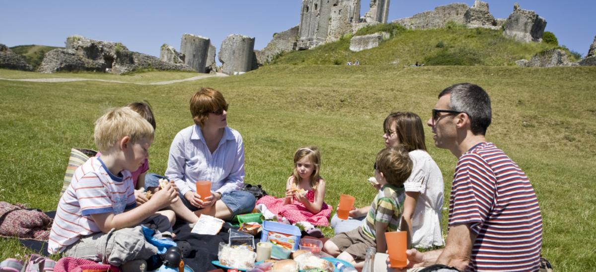 Three people having a picnic at Sandsfoot Castle, Weymouth, Dorset