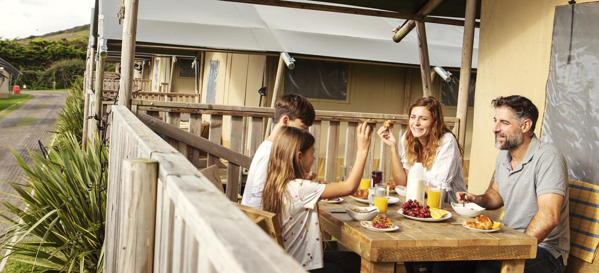 A family dinner outside at a glamping tent at Parkdean Resorts