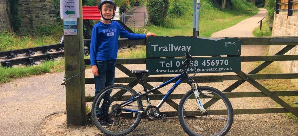 Young boy standing next to the sign for the North Dorset Trailway