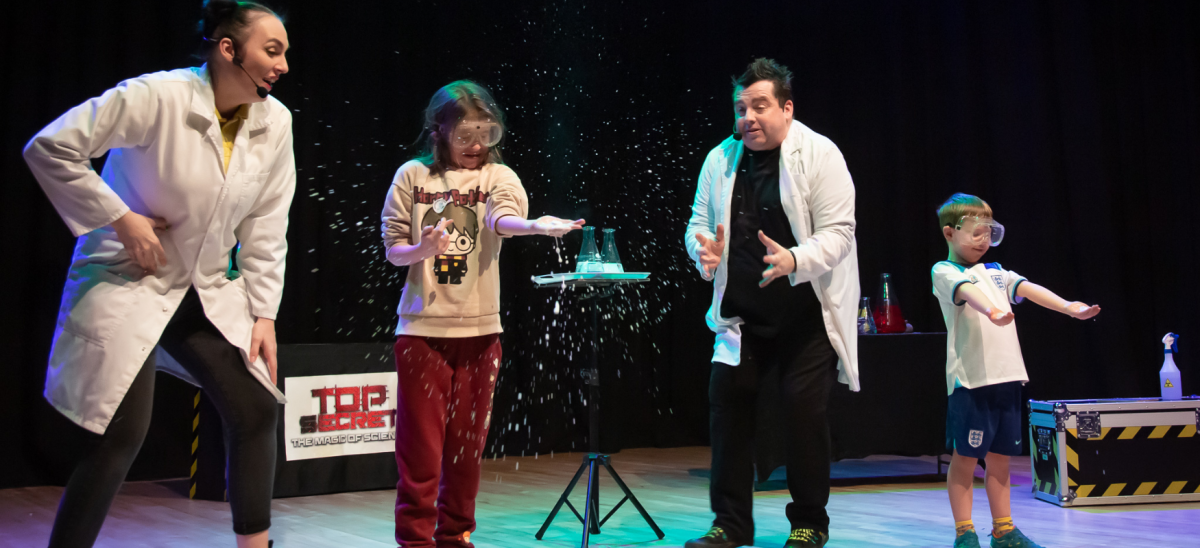 Children partaking in a science experiment on stage