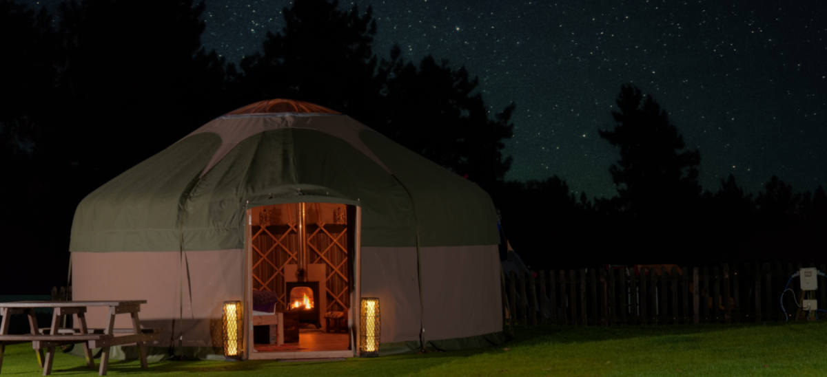 glamping yurt pictured with a starry night sky behind