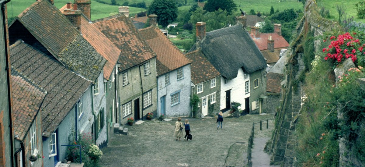 Three people walking down Gold Hill in Shaftesbury, Dorset