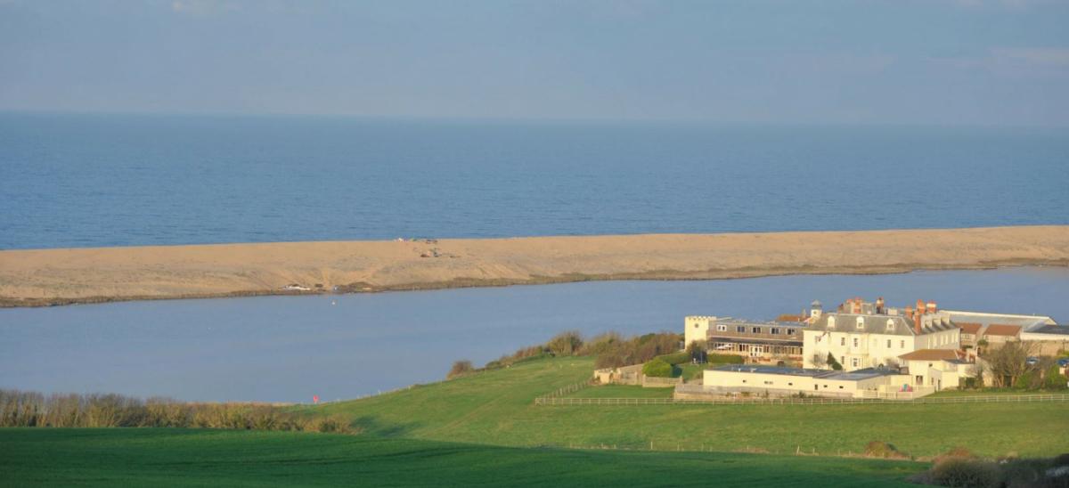 View of Moonfleet Manor Hotel with Chesil Beach and The Fleet lagoon in the distance