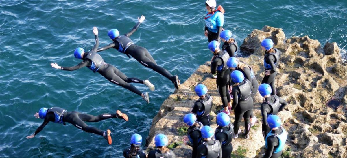 A group of people coasteering on the Dorset coast with Cumulus Outdoor Adventure guides
