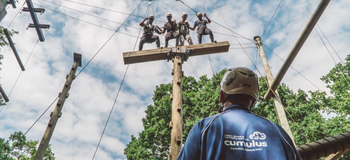 Four people taking part in a high ropes course with Cumulus Outdoors