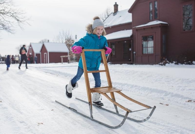 Little girl kick-sledding at Historic Eidem Farm