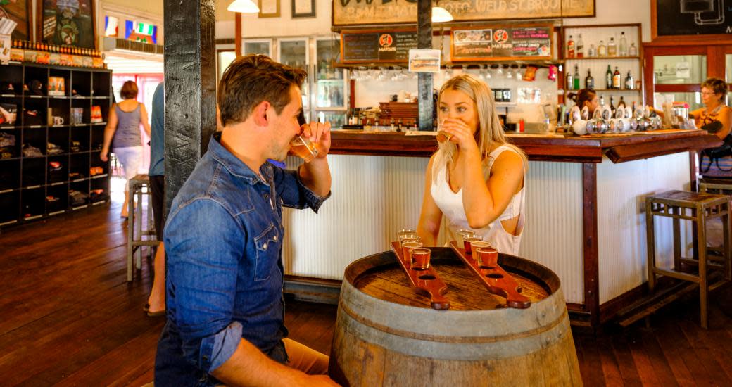 Two people enjoying some tasting paddles at Matso's Brewery
