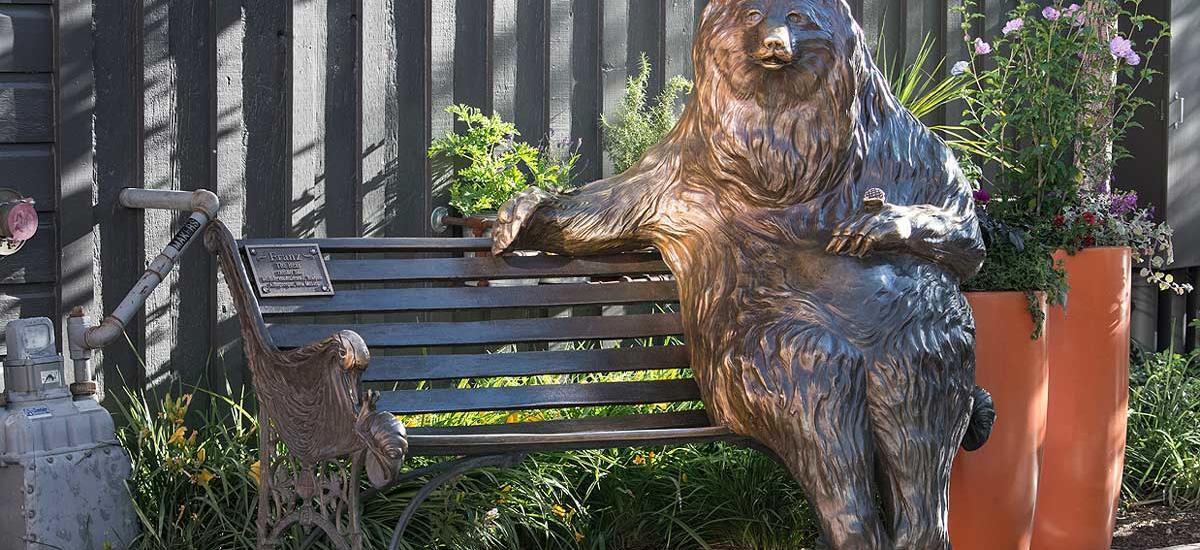 A statue of a bear on a bench on Main Street in Park City, UT