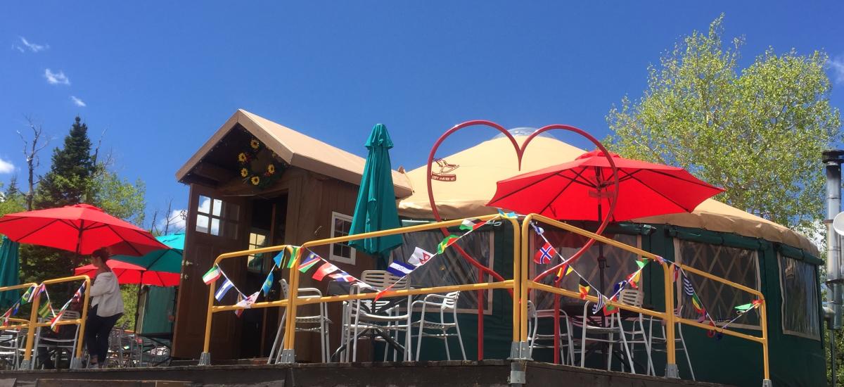 A patio with umbrellas outside of a yurt