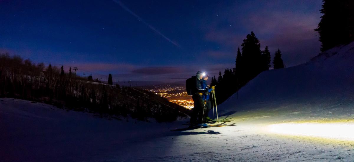 Two skiers tour on Park City Mountain with headlamps