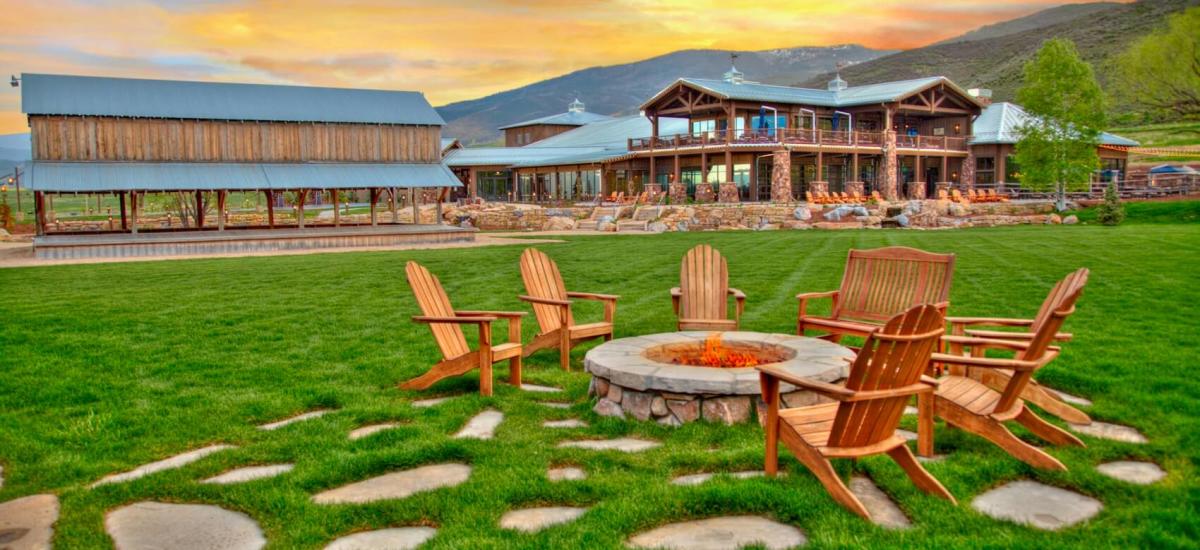Chairs around a fire pit during sunset
