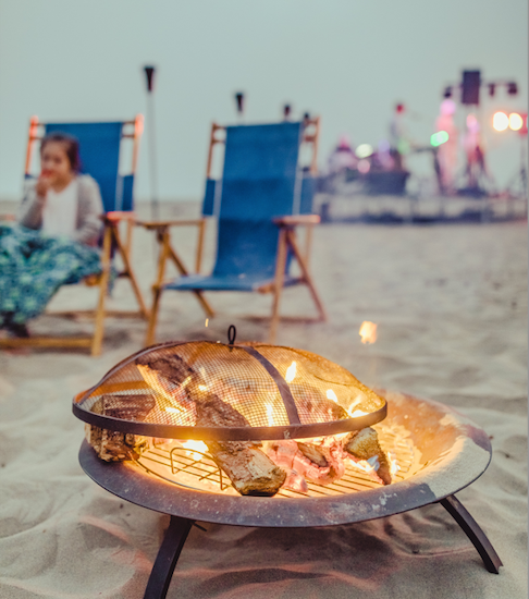 Fire in a fire pit on the beach.