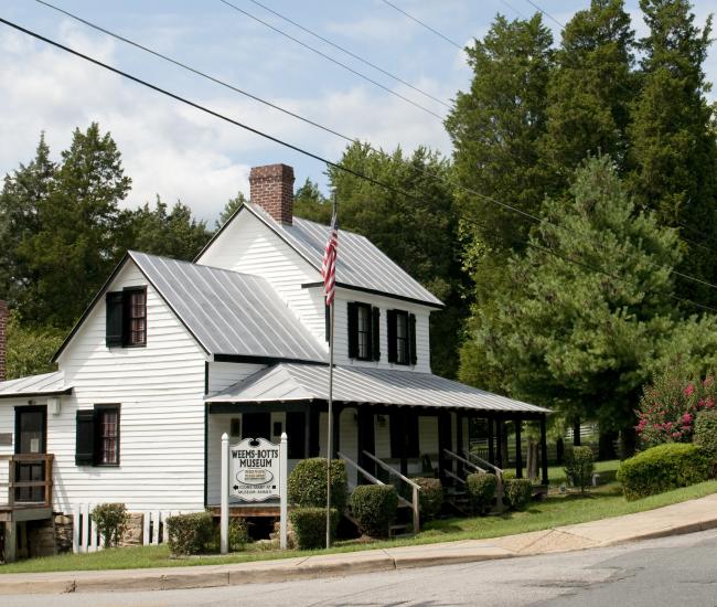 A historic white building with trees behind it