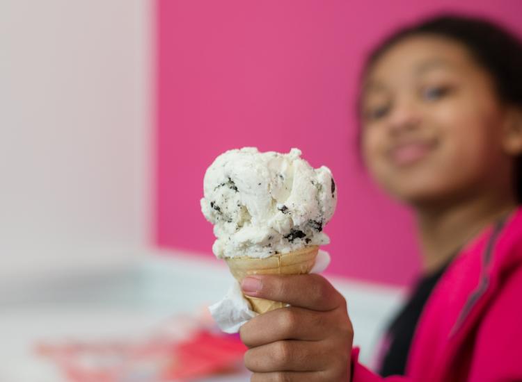 Kid holds out ice cream cone