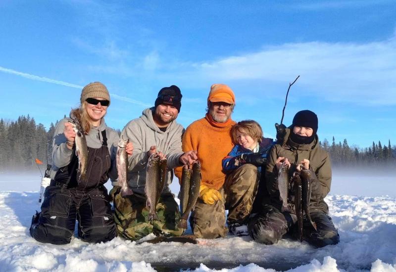 Family showing ice fishing catch in February 2024