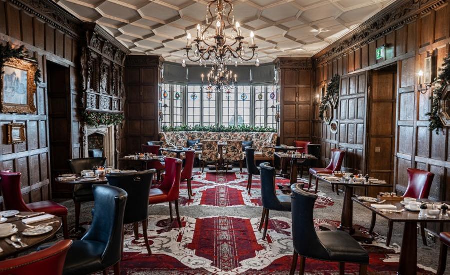 A chandalier lights up the restaurant at Ellenborough Park with its wood panelled walls, ornate ceiling and patterned floor