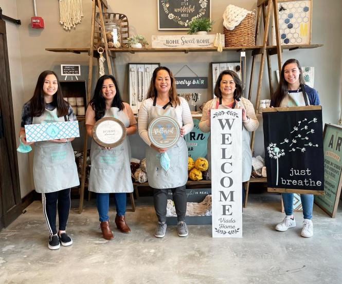 A family shows off theiur completed crafts at AR Workshop.