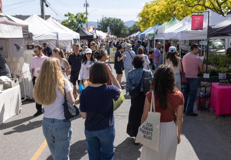 Crowd Strolling Through a Sunny Farmers Market Lined with Vendor Tents