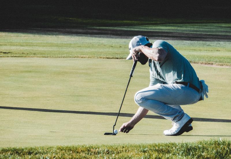 Man-placing-golf-ball-on-the-grass