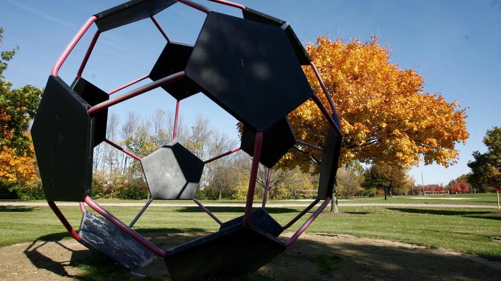 Giant metal soccer bar art installation in a fall colored park.