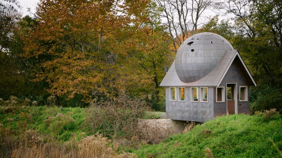 Watch House public art installation surrounded by trees and grass in fall color.