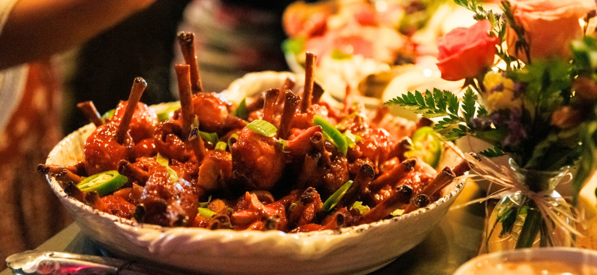 an entree dish on the table with a vase of flowers