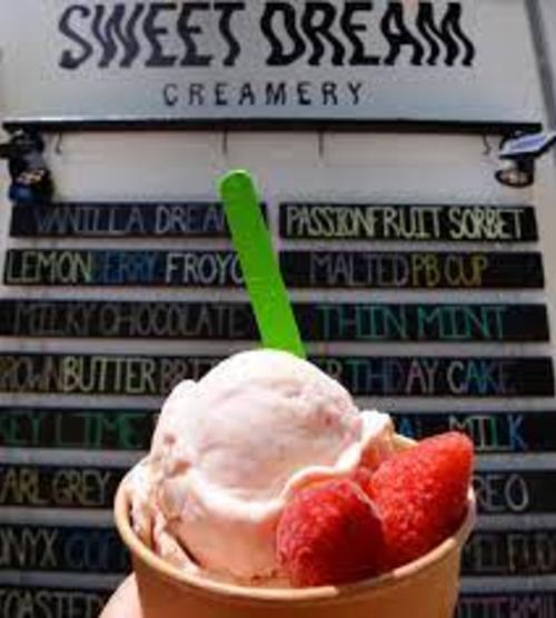 Strawberry ice cream in a cup with fresh strawberries