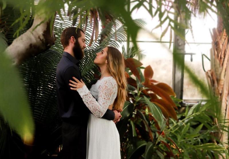 A couple embracing and looking at one another at the IU Biology Greenhouse