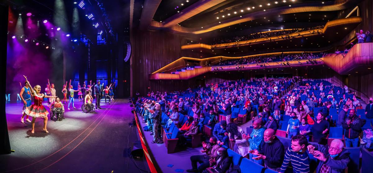 Performers on stage receive applause by a packed house at the Miller Auditorium.