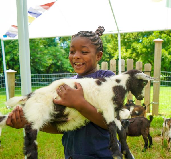 The Traveling Child holding a goat at Providence Hill Farm