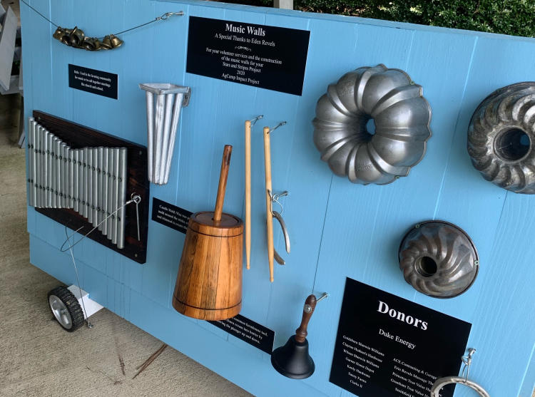 A blue board with historical musical instruments tacked on for display.
