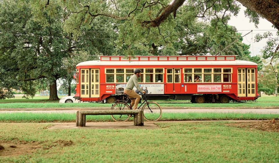 Canal Street Streetcar Passing A Biker in City Park