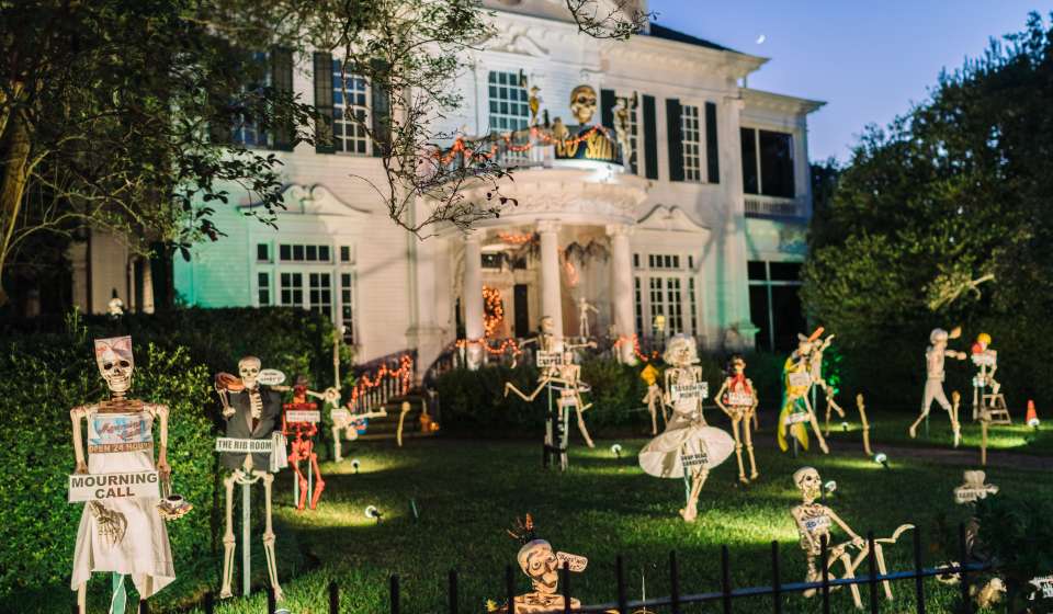 Mansion with spooky skeletons and decorations on the lawn