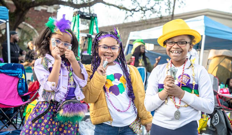 Kids Waiting for A Mardi Gras Parade to Roll