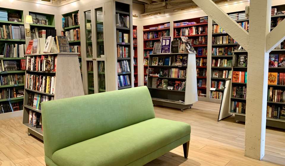 books on shelves and a couch in the interior of Garden District Book Shop