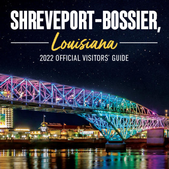 2022 Visitors' Guide Cover Cropped - LED-lit Bakowski Bridge of Lights on the Texas Street Bridge over the Red River in foreground, background of Bossier City skyline at night