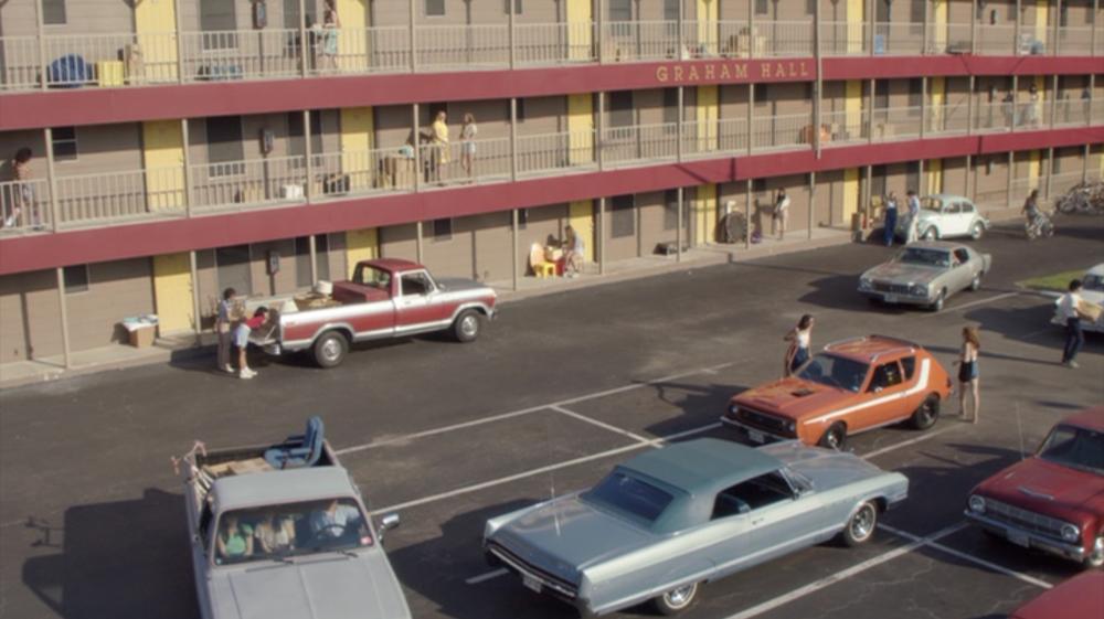 Everybody Wants Some!! screengrab showing the Graham Hall dormitories with red balconies and 1970s-era cars parked in front