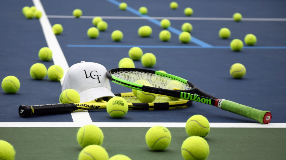 A bunch of tennis balls on a tennis court