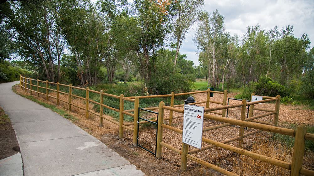 Summertime Cerise Park parking area entrance to Cerise Dog Park. Park is gated and has a calming area for dogs before entering the park.