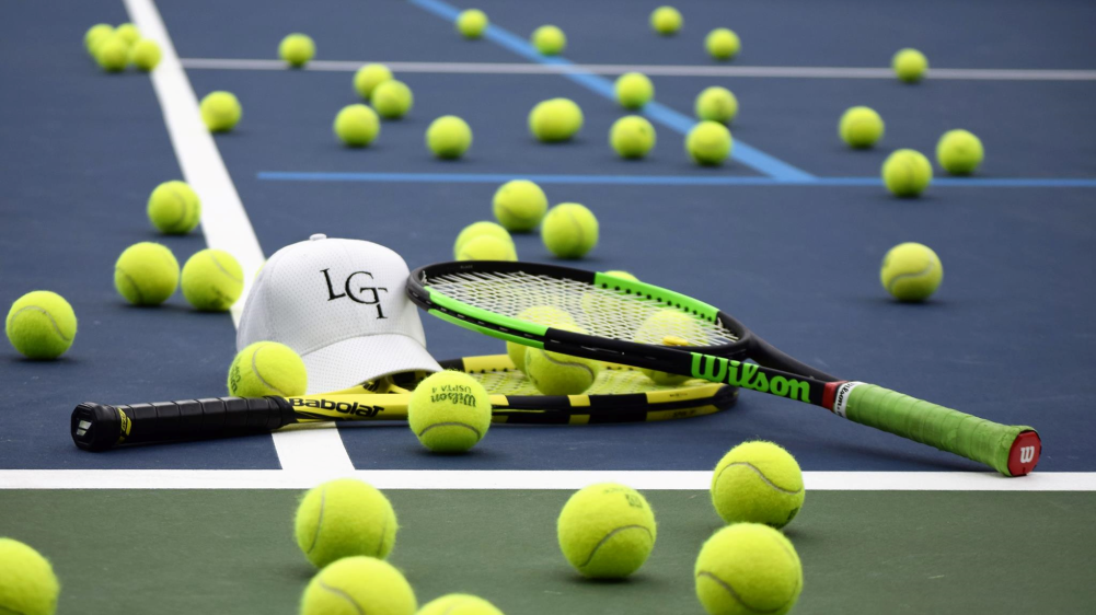 A bunch of tennis balls on a tennis court