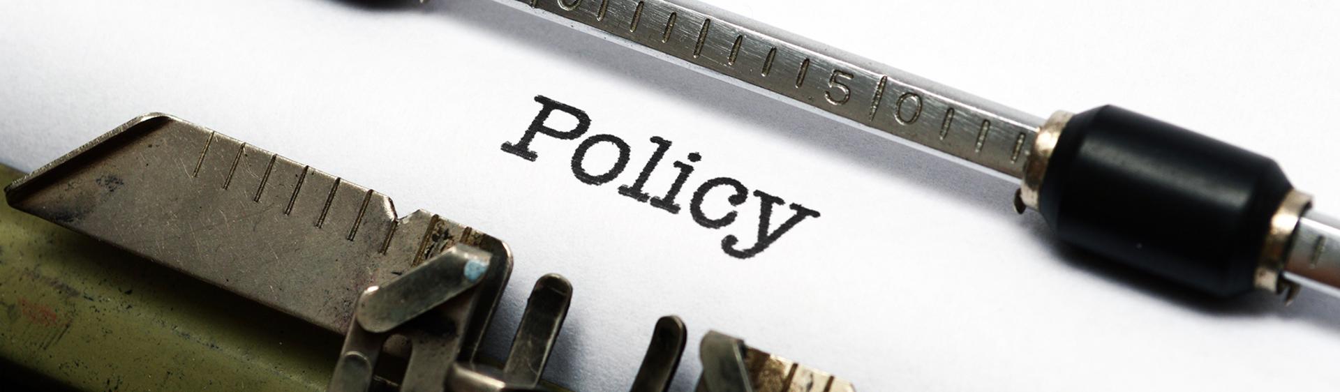 The word "Policy" typed on a typewriter for the JCVB website.