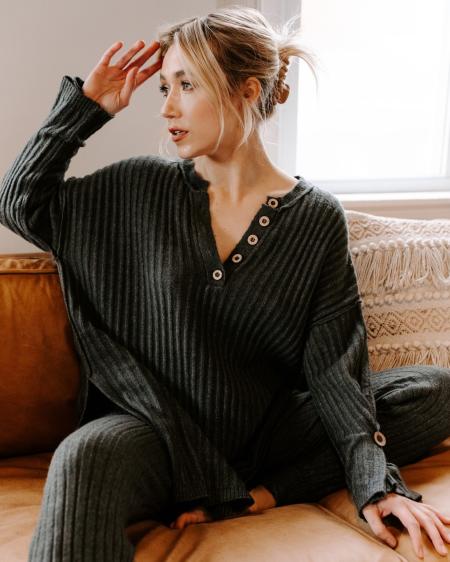 A girl with blonde hair sits on a couch.