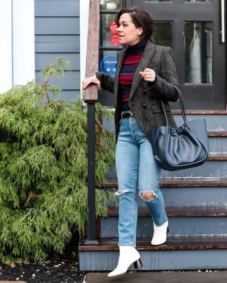 White woman in a blazer stepping down steps