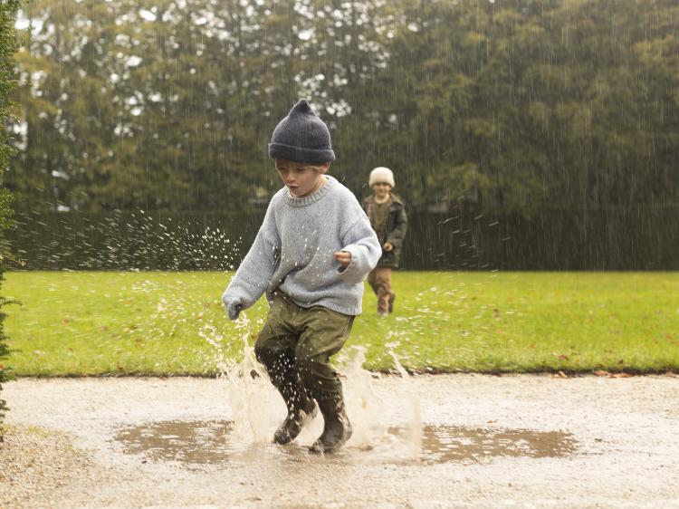 A child jumping in puddles at Castle Drogo